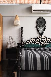 a bedroom with a bed with a black and white comforter at Qalb in Mandya