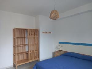 sypialnia z łóżkiem i drewnianymi półkami na książki w obiekcie Villa Acquamarina w mieście Calasetta