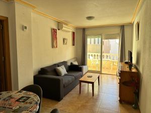 salon z kanapą i stołem w obiekcie Homely Apartments Alcatri w mieście Torrevieja