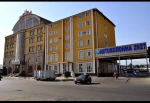 a large building with a car parked in front of it at Sakhohostel in Karategin