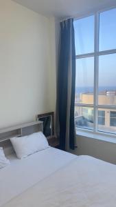 a bedroom with a bed and a large window at P3) Fantastic Seaview Room with shared bath inside 3bedroom apartment in Ajman 