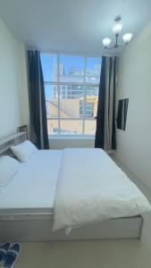 Un dormitorio con una cama y una ventana grande. en P3) Fantastic Seaview Room with shared bath inside 3bedroom apartment, en Ajman