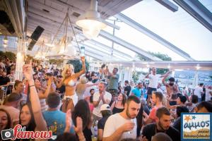 a crowd of people standing in a crowd at a party at 4Seasons Suites Paradise Near Airport in Markopoulo
