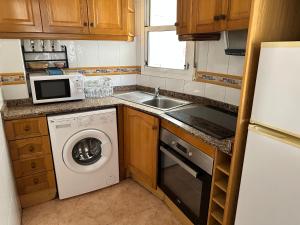 cocina pequeña con lavadora y microondas en Homely Apartments Alcatri, en Torrevieja