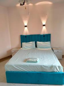 a blue bed with two lights on top of it at Lazorde bay Sidi Abd El Rahman لازوردى باى apartment in El Alamein