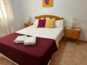 sypialnia z dużym łóżkiem i dwoma ręcznikami na nim w obiekcie Homely Apartments Alcatri w mieście Torrevieja +21 zdjęć