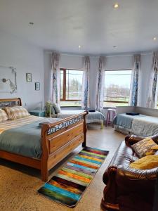 1 dormitorio con 2 camas y sofá en Lus Mor, en Roundwood