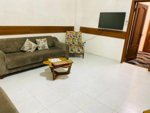 ein Wohnzimmer mit einem Sofa und einem Stuhl in der Unterkunft Sakhohostel in Karategin