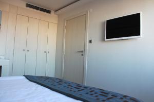 1 dormitorio con 1 cama y TV en la pared en Hotel Svilena en Svilengrad