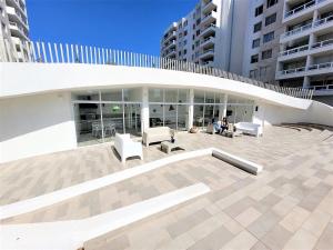 a large building with white furniture and buildings at Condominio Pacífico 3100 in La Serena