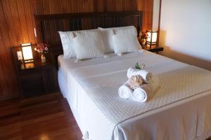 1 dormitorio con 1 cama con 2 toallas en Pousada Gauleses, en Praia do Rosa