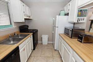 een keuken met witte kasten, een wastafel en een koelkast bij Sandpiper Cove 3209 condo in Destin