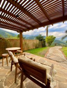 聖弗朗西斯澤維爾的住宿－Pousada Varandas da Mantiqueira，庭院设有长凳和一张桌子,享有美景。