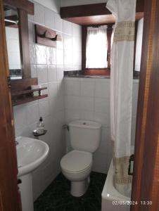 a white bathroom with a toilet and a sink at Apartamentos Las Rocas de Brez in Brez +68 photos