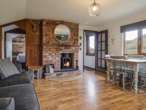 a living room with a fireplace and a table and chairs at Pengeulan in Machynlleth