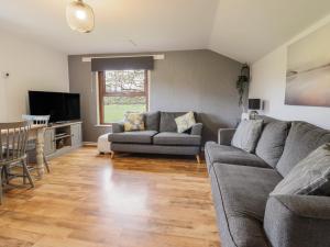 a living room with two couches and a television at Pengeulan in Machynlleth