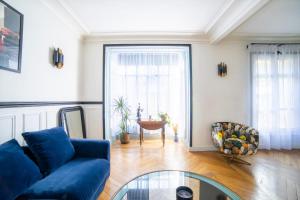ein Wohnzimmer mit einem blauen Sofa und einem Glastisch in der Unterkunft Cozy one bedroom Appartement 16 ème Paris - Trocadéro in Paris