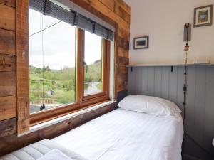 a bedroom with a bed and a window at Pengeulan in Machynlleth