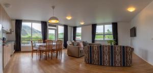 eine Küche und ein Wohnzimmer mit einem Tisch und Stühlen in der Unterkunft Hótel Skógafoss by EJ Hotels in Skógar