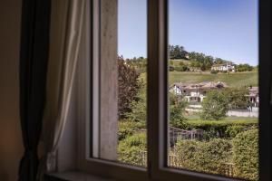 a window with a view of a house at “villa Francesco” in Nizza Monferrato