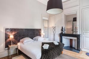1 dormitorio con 1 cama grande y chimenea en La Maison du Champlain - Chambres d'hôtes, en Lille