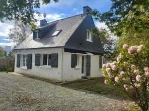 een wit huis met een zwart dak bij Vers la crique de Bot-Conan in Fouesnant