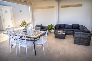 a living room with a table and chairs and a couch at La Terrazza Nel Borgo B&B in Copertino