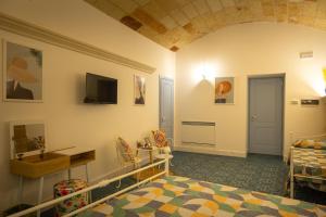 a room with a bed and a tv on the wall at La Terrazza Nel Borgo B&B in Copertino