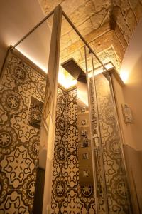 uma casa de banho com uma escadaria com papel de parede ornamentado em La Terrazza Nel Borgo B&B em Copertino