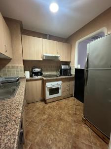a kitchen with a stainless steel refrigerator and cabinets at Appartement in Tetouan