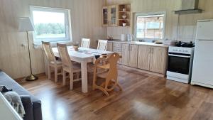 a kitchen with a table and chairs and a kitchen with a refrigerator at Plagandõ puhkemaja in Leimani +4 photos