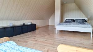 a bedroom with a white bed and a wooden floor at Plagandõ puhkemaja 
