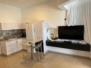 a kitchen with a television and a table and chairs at Sweet li in Ashqelon