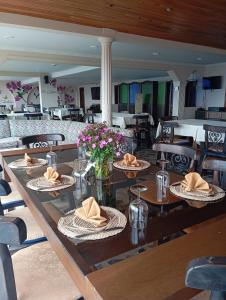 einen langen Holztisch mit Teller Essen drauf in der Unterkunft Di Carbone Hotel Gastrobar in Facatativá