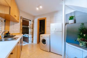 a kitchen with a white refrigerator and a washing machine at Infinity Residence - Charming Retreat in Kos in Kos