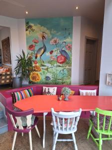 朗德伍德的住宿－Lus Mor，红色的桌子和椅子,墙上有绘画作品