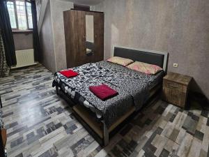 a bedroom with a bed with two red pillows on it at Kiev hotel in Tbilisi City
