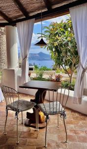 利帕里的住宿－Case Quattrocchi，窗前的一张桌子和两把椅子