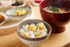 Hotel Kanazawa Zoushi في كانازاوا: وعاء من الأرز على طاولة مع أطباق أخرى من الطعام