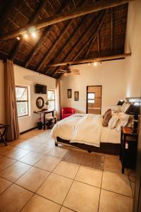 um quarto com uma cama grande e uma mesa em Blue Hills Lodge em Midrand