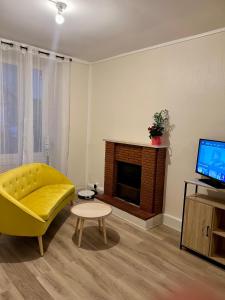 ein Wohnzimmer mit einem gelben Sofa und einem Kamin in der Unterkunft Chez Olivia in Melle