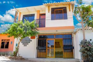 una casa con una puerta amarilla y un árbol en Hospedaje Guadalupe Inn en Máncora