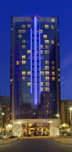 a large building with blue lights on it at night at Al Manzel Hotel Apartments in Abu Dhabi