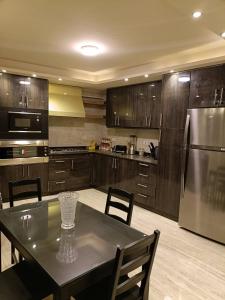 a kitchen with a table and a stainless steel refrigerator at LUXURY APARTMENT Dokki in Cairo