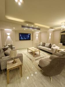a living room with two couches and a tv at LUXURY APARTMENT Dokki in Cairo