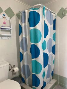 ein Bad mit einem blauen und weißen Duschvorhang in der Unterkunft Irinis Apartment in Kalamata in Kalamata