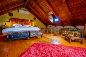 a bedroom with a large bed and a red rug at Vila Voula in Aristi