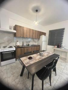 kuchnia ze stołem, kuchenką i lodówką w obiekcie Blue Mind House w mieście Nea Kios