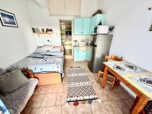 a small kitchen with a bed and a table in a room at Stories of Samos beach studio 1 in Kámpos
