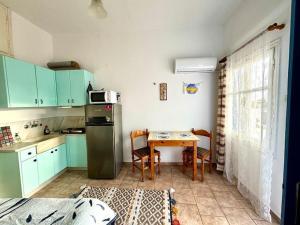 a small kitchen with a table and a refrigerator at Stories of Samos beach studio 1 in Kámpos